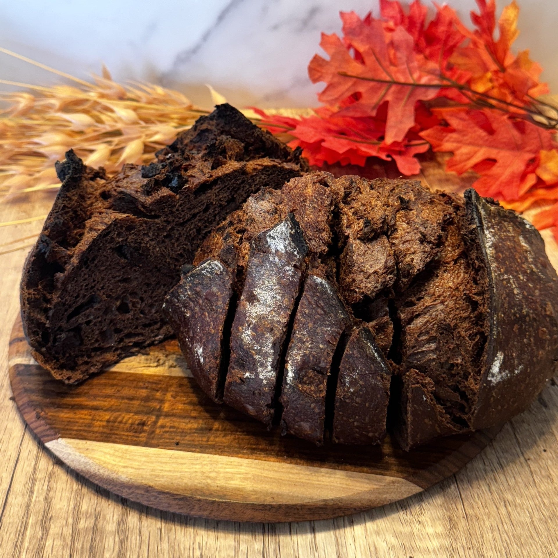 Sliced chocolate bread on a wooden board with a blurred background
